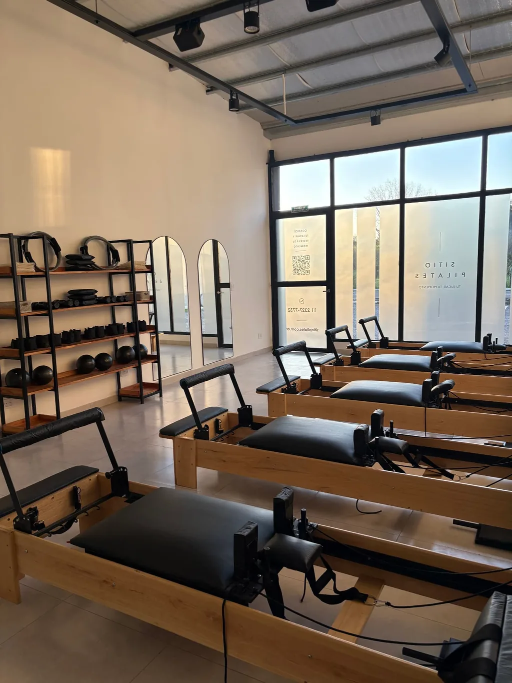 Interior del estudio Sitio Pilates: reformers de madera y luz natural en Pilar